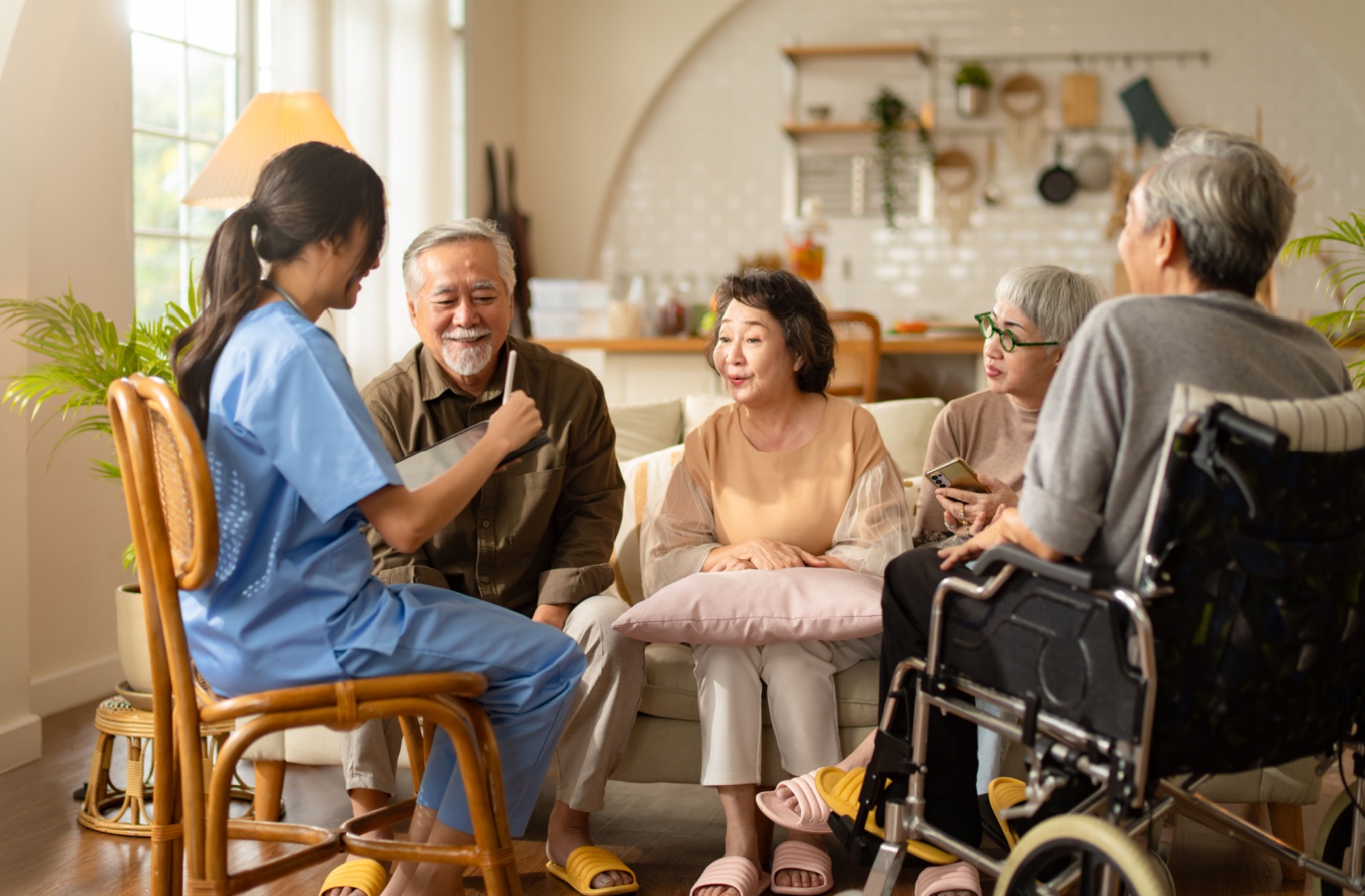 A group of seniors spending time together at an assisted living community, chatting with one of the nurses.