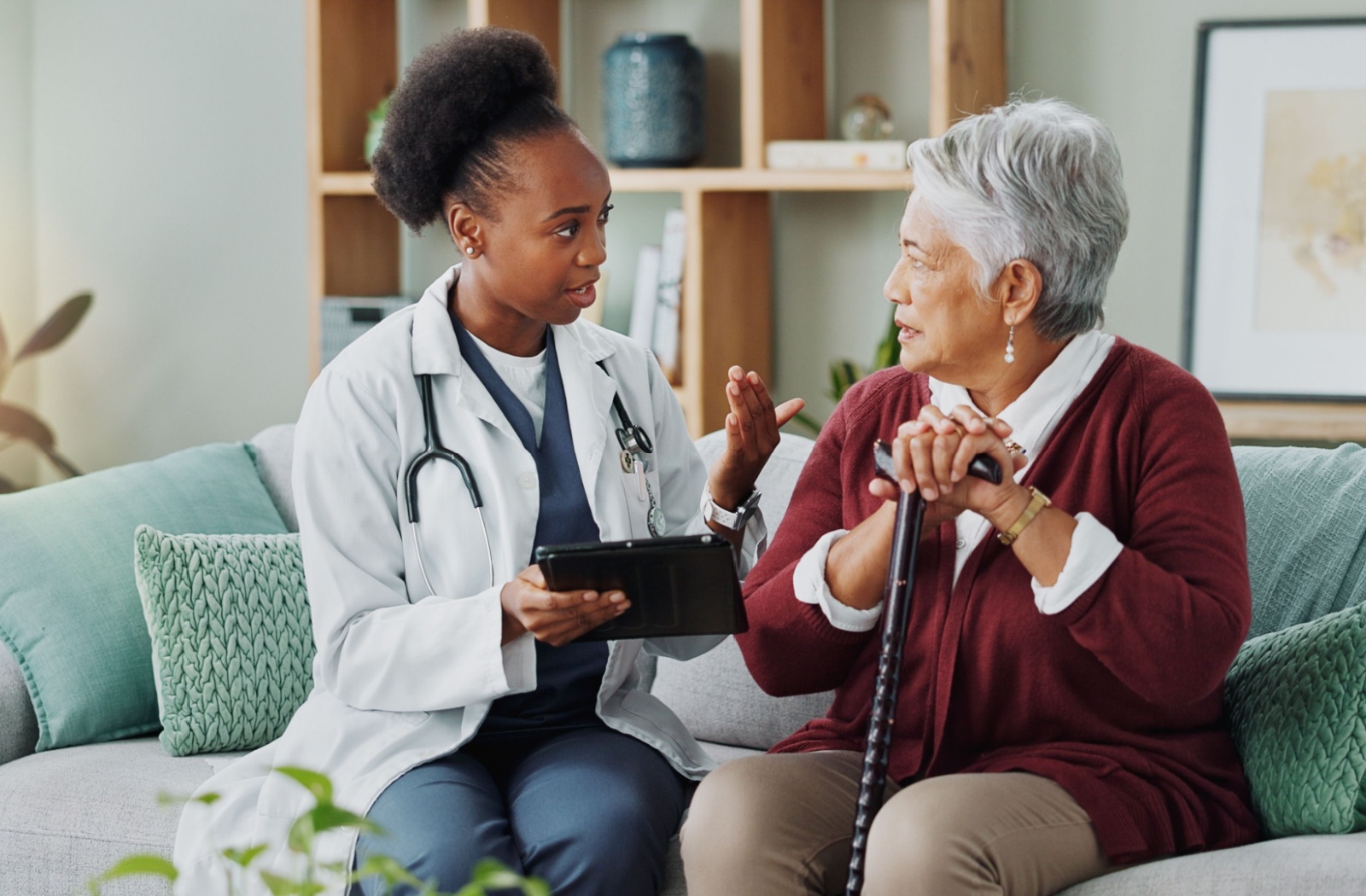 A senior woman discussing her medical care with a nurse at a skilled nursing facility.
