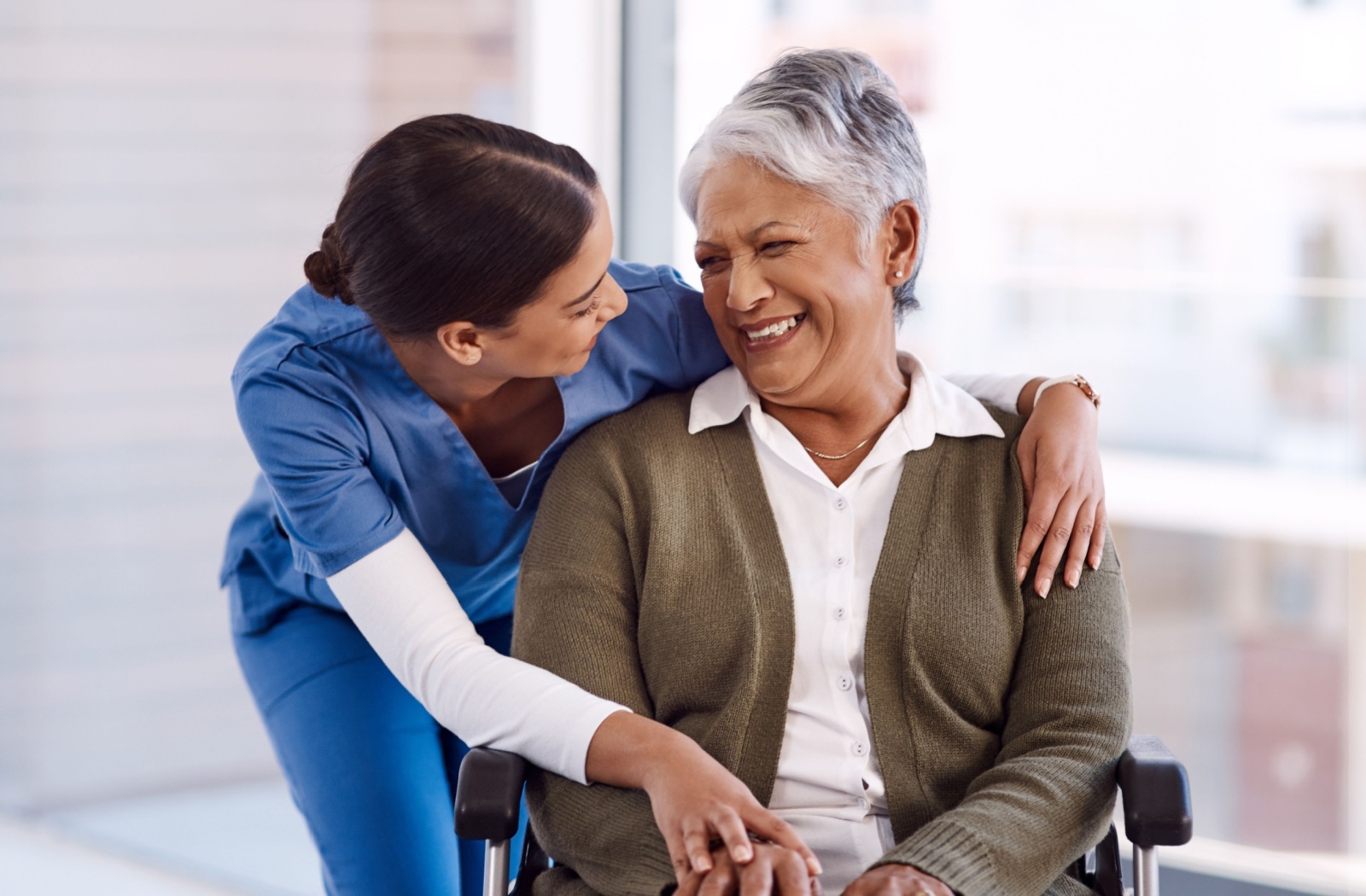 A mature woman smiling with care staff while in respite care.