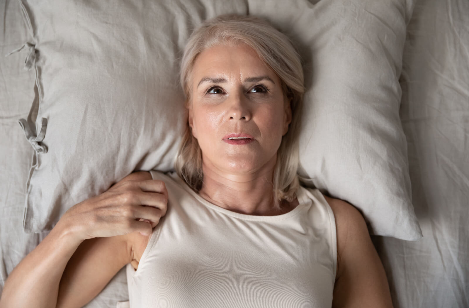 An older adult lying awake at night and staring at their ceiling.
